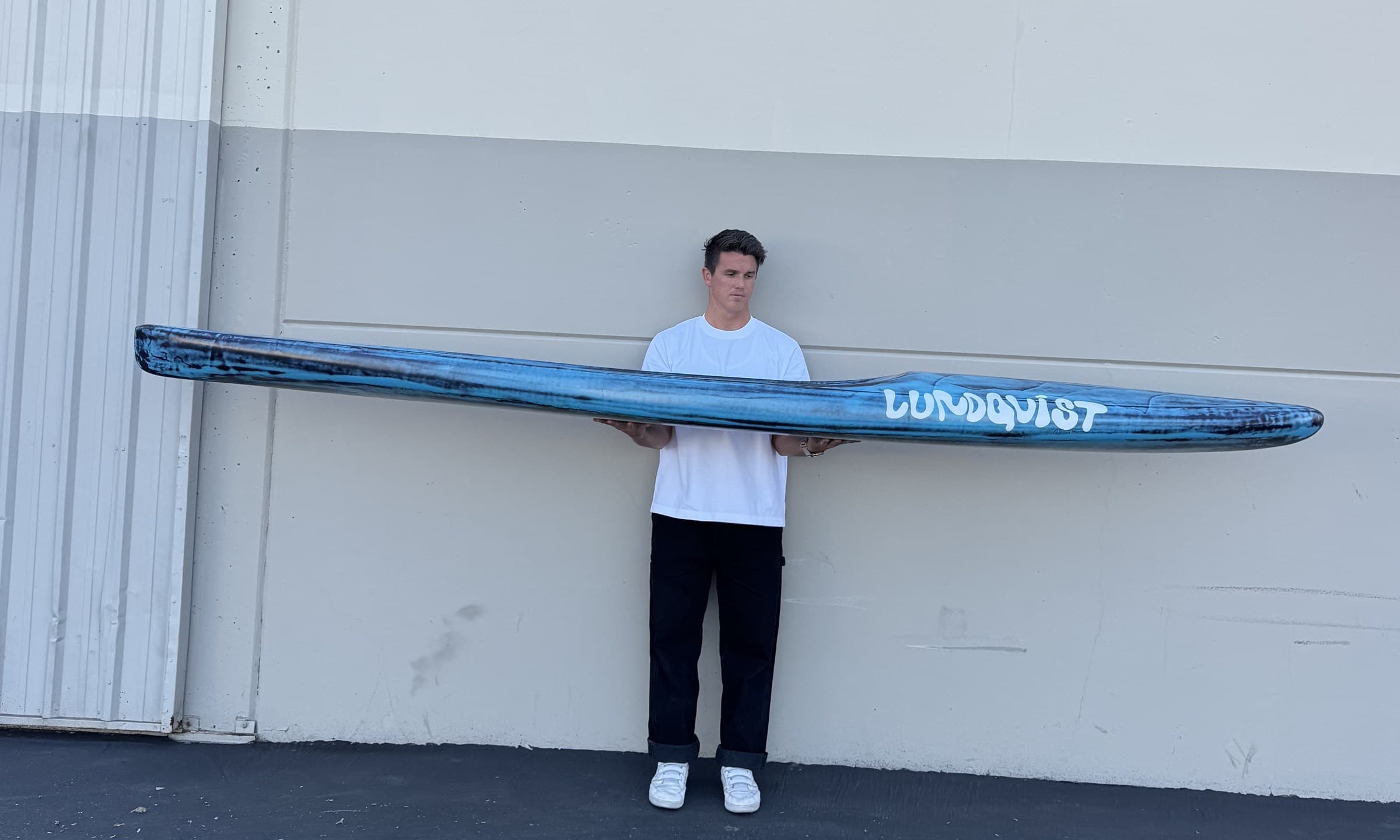 Side profile of a custom Lundquist prone paddleboard, the full rail line, nose rocker to tail.